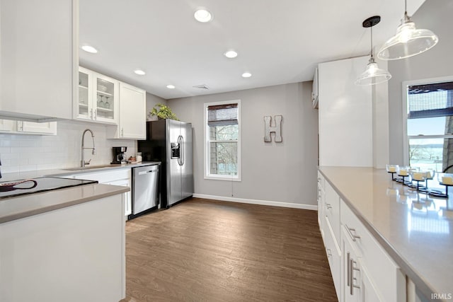 617 Pearl St, Culver, IN 46511 - kitchen with backsplash, white cabinets, dark wood-type flooring, stainless steel appliances, and a sink