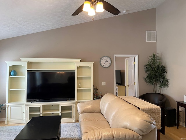 living room with visible vents, a textured ceiling, wood finished floors, and ceiling fan