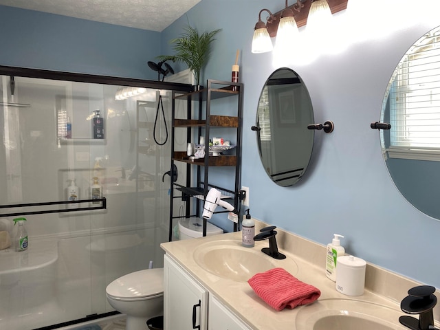 bathroom with toilet, a stall shower, and vanity