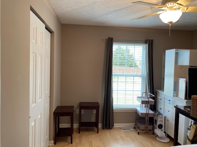 bedroom featuring light wood-style floors, ceiling fan, baseboards, and multiple windows