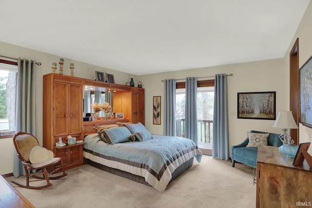 bedroom featuring access to exterior, multiple windows, and light carpet