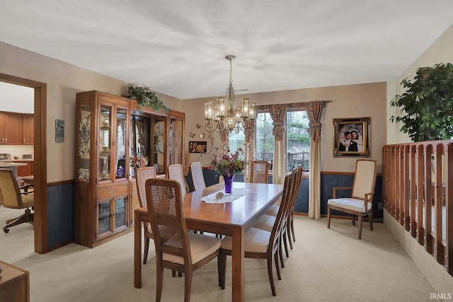 dining space featuring a chandelier and light carpet