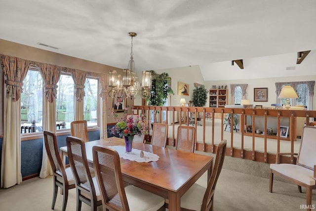 dining space featuring a chandelier, visible vents, and light colored carpet