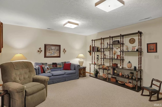 carpeted living area featuring visible vents, baseboards, and a textured ceiling