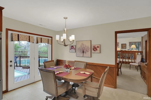 dining room with visible vents, an inviting chandelier, a wainscoted wall, and light tile patterned flooring