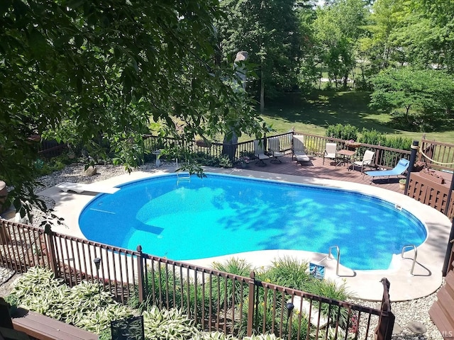 view of pool featuring a fenced in pool, a diving board, a wooden deck, and fence