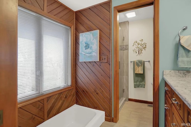 bathroom featuring wood walls, a shower stall, a washtub, and vanity