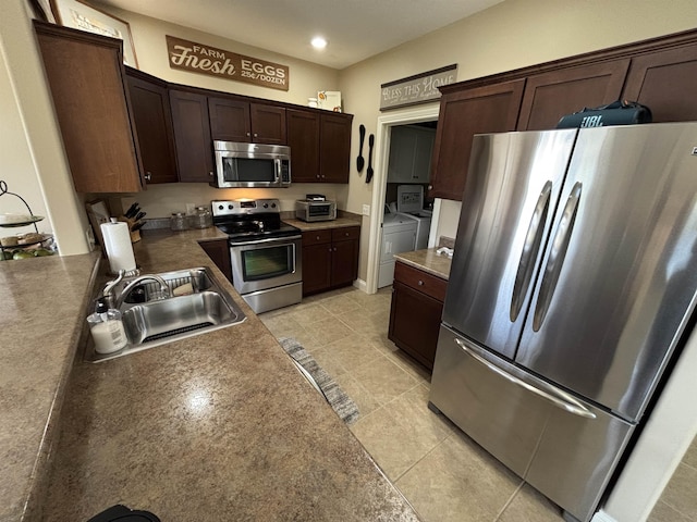 721 Anchors Way, Culver, IN 46511 - kitchen featuring light tile patterned floors, a sink, appliances with stainless steel finishes, washing machine and dryer, and dark brown cabinetry