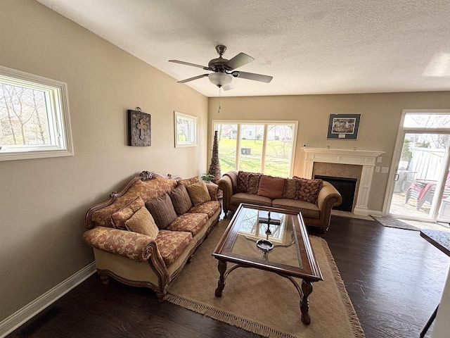 721 Anchors Way, Culver, IN 46511 - living room featuring dark wood-type flooring, a tiled fireplace, and baseboards