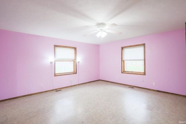 unfurnished room with tile patterned floors, visible vents, baseboards, and a ceiling fan
