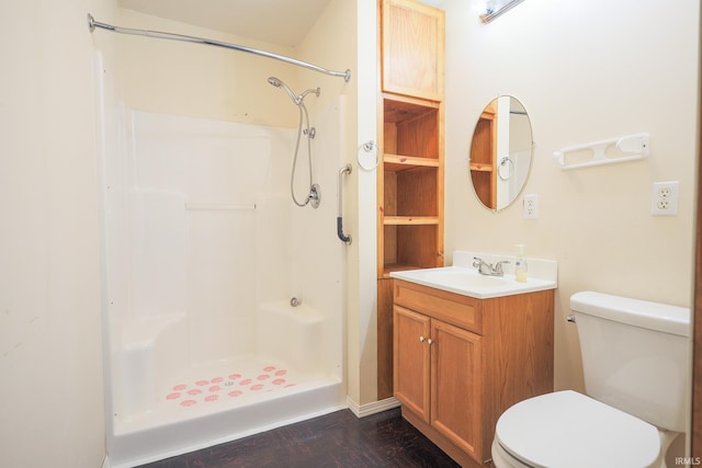 full bathroom with toilet, wood finished floors, vanity, and walk in shower