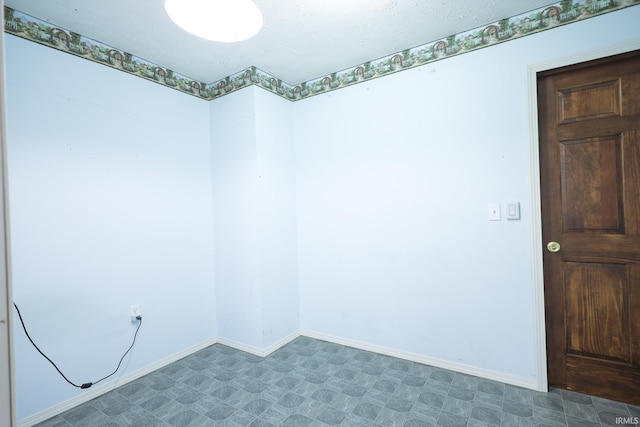 empty room featuring tile patterned floors and baseboards