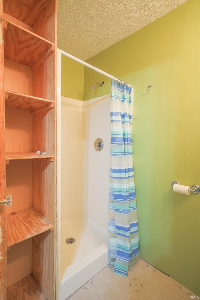 full bathroom with tile patterned floors, a shower with shower curtain, and a textured ceiling