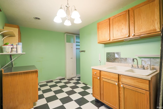 kitchen featuring visible vents, a sink, light countertops, a chandelier, and light floors