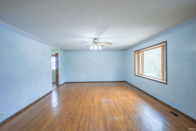unfurnished room with visible vents, baseboards, a ceiling fan, a textured ceiling, and wood finished floors