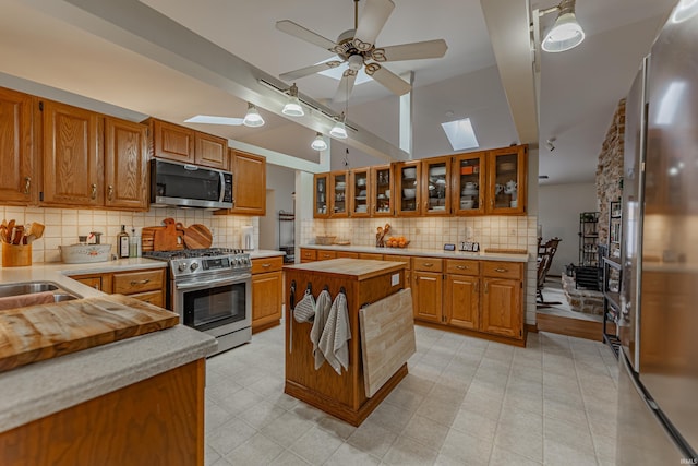 379 Pleasant View Dr, Evansville, IN 47711 - kitchen featuring stainless steel appliances, tasteful backsplash, wood counters, and brown cabinetry