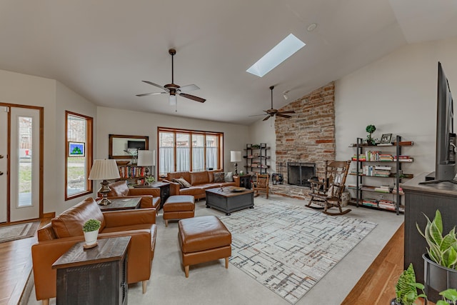 379 Pleasant View Dr, Evansville, IN 47711 - living room with a stone fireplace, light wood-type flooring, a ceiling fan, and lofted ceiling with skylight