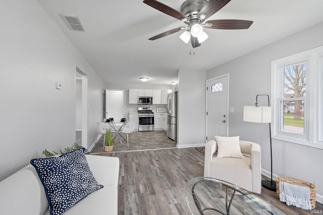 11314 NE Wawasee Dr, Syracuse, IN 46567 - living room featuring visible vents, ceiling fan, baseboards, and wood finished floors