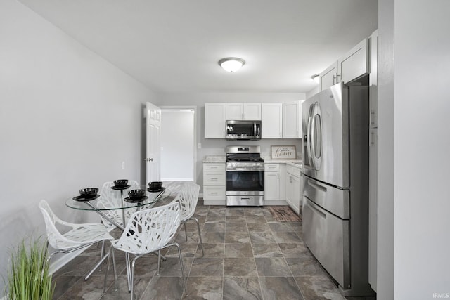 11314 NE Wawasee Dr, Syracuse, IN 46567 - kitchen with stone finish floor, light countertops, white cabinetry, and stainless steel appliances