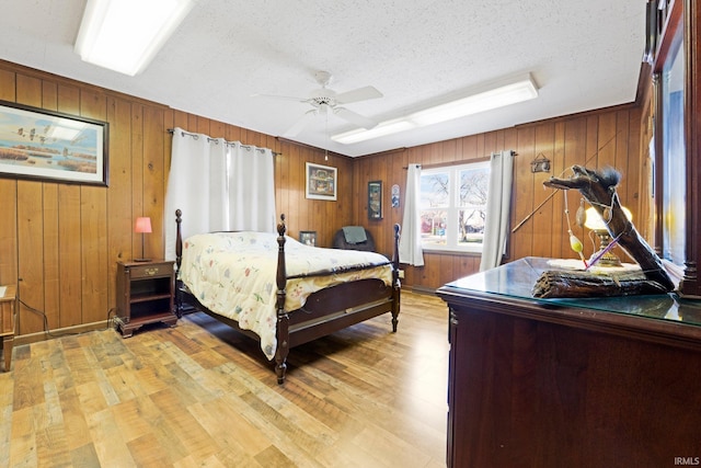 328 W Market St, Bluffton, IN 46714 - bedroom featuring a textured ceiling, wooden walls, and light wood-style flooring