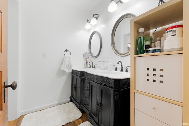 328 W Market St, Bluffton, IN 46714 - bathroom featuring baseboards, wood finished floors, a sink, and double vanity