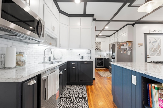 328 W Market St, Bluffton, IN 46714 - kitchen with white cabinets, beverage cooler, a sink, light stone countertops, and appliances with stainless steel finishes