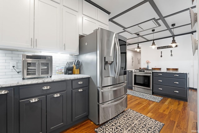 328 W Market St, Bluffton, IN 46714 - kitchen featuring white cabinets, stainless steel appliances, decorative backsplash, wood finished floors, and light stone counters