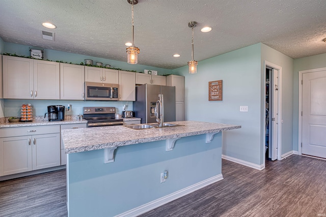 9919 Blyth Dr, Evansville, IN 47725 - kitchen featuring visible vents, a kitchen breakfast bar, a textured ceiling, dark wood-style floors, and stainless steel appliances