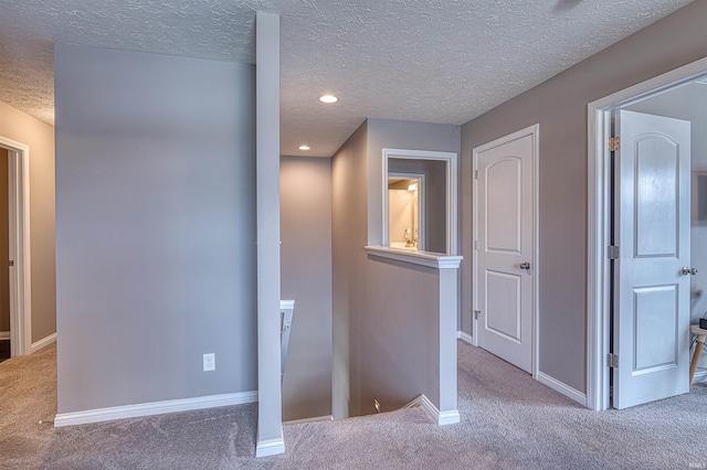 9919 Blyth Dr, Evansville, IN 47725 - hall featuring a textured ceiling, baseboards, carpet, and an upstairs landing