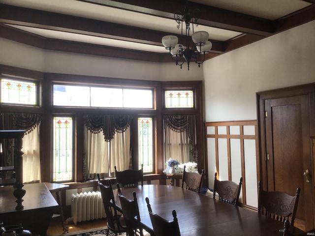 dining space featuring radiator heating unit, beam ceiling, and a chandelier