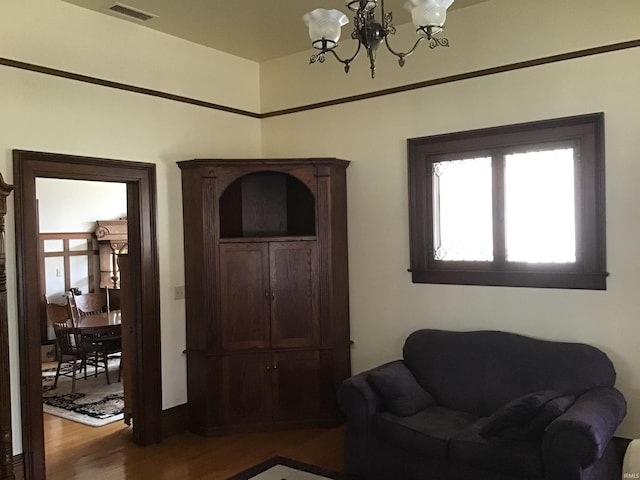 sitting room featuring visible vents, an inviting chandelier, and wood finished floors