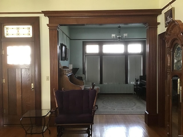 entryway featuring radiator heating unit, a notable chandelier, and wood finished floors