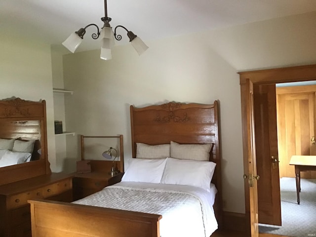 carpeted bedroom featuring an inviting chandelier