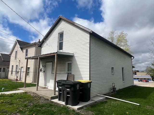 rear view of house featuring a yard