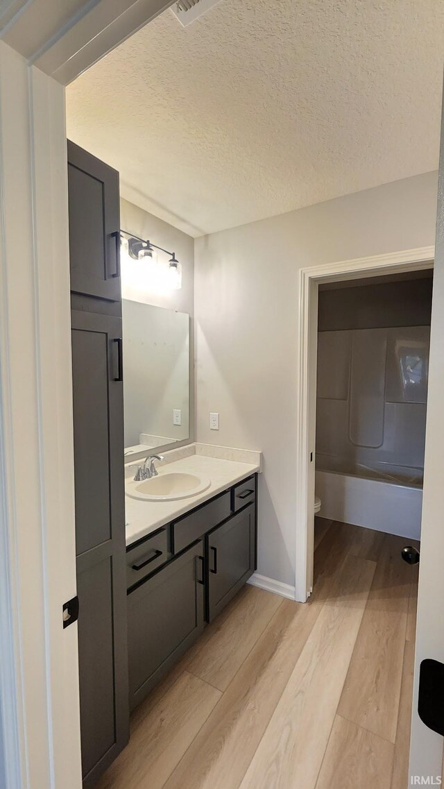 1332 Pueblo Trl, Fort Wayne, IN 46845 - bathroom with wood finished floors, vanity, a textured ceiling, toilet, and baseboards