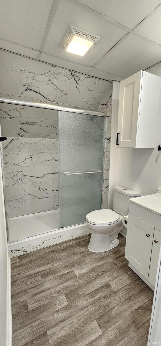 910 Harriet St, Evansville, IN 47710 - full bath featuring vanity, toilet, a marble finish shower, visible vents, and wood finished floors