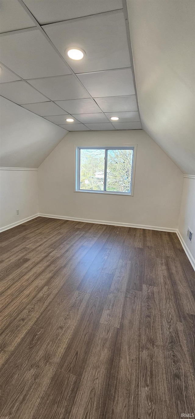 910 Harriet St, Evansville, IN 47710 - additional living space with visible vents, baseboards, vaulted ceiling, and dark wood-style floors