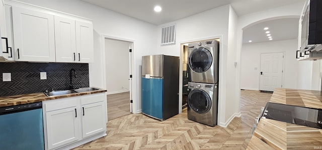 910 Harriet St, Evansville, IN 47710 - washroom with recessed lighting, stacked washer / dryer, visible vents, arched walkways, and a sink