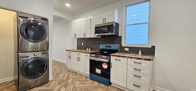 910 Harriet St, Evansville, IN 47710 - kitchen with wooden counters, stacked washer / dryer, decorative backsplash, arched walkways, and appliances with stainless steel finishes