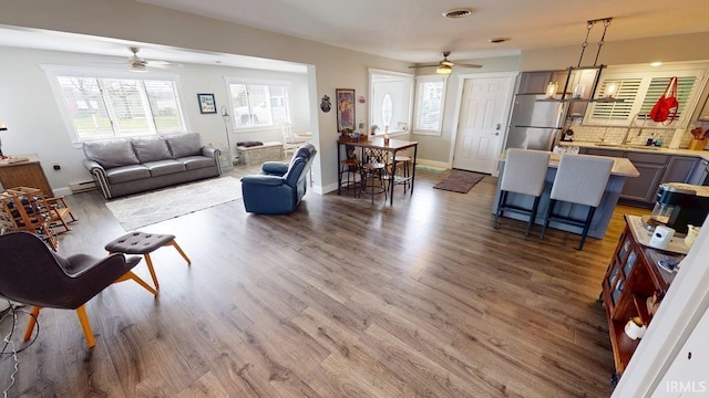 10509 N Lakeview Dr, Monticello, IN 47960 - living area featuring a baseboard heating unit, ceiling fan, visible vents, baseboards, and wood finished floors