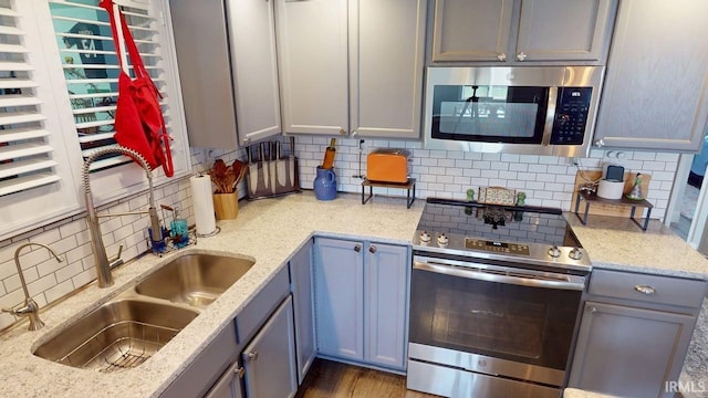 10509 N Lakeview Dr, Monticello, IN 47960 - kitchen with light stone countertops, a sink, stainless steel appliances, gray cabinets, and tasteful backsplash