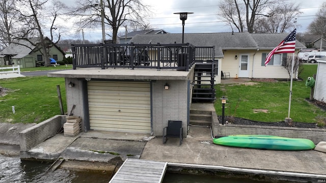 10509 N Lakeview Dr, Monticello, IN 47960 - rear view of house with a garage, a yard, a deck with water view, stairs, and brick siding