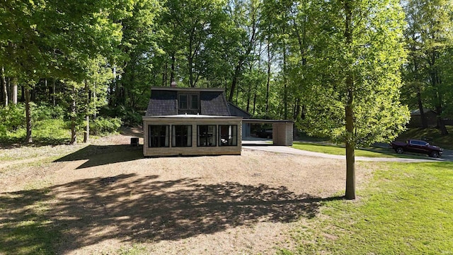 505 Longtree Ln, Logansport, IN 46947 - back of house with dirt driveway, an attached carport, a sunroom, and a yard