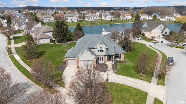 drone / aerial view featuring a water view and a residential view