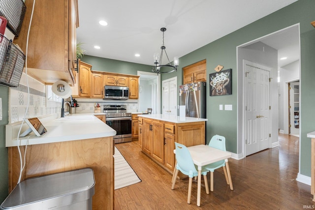 kitchen featuring light countertops, light wood-style floors, appliances with stainless steel finishes, and a sink