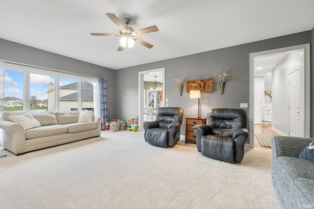 living room featuring stairway, carpet, and a ceiling fan