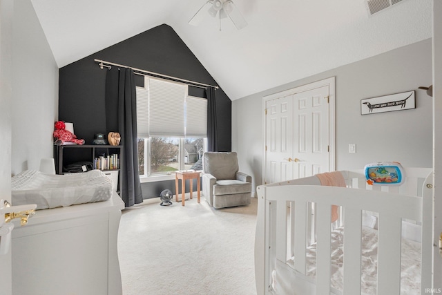 carpeted bedroom with a closet, visible vents, a ceiling fan, and lofted ceiling