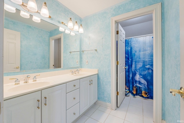 bathroom featuring a sink, tile patterned floors, double vanity, and baseboards