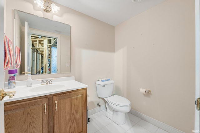 half bathroom featuring tile patterned flooring, vanity, baseboards, and toilet