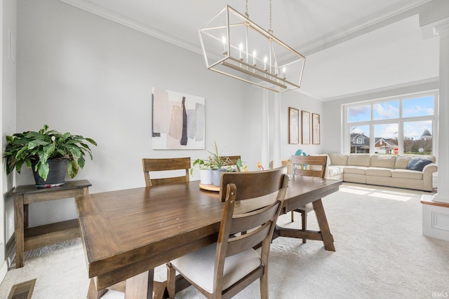 carpeted dining space with crown molding, an inviting chandelier, and visible vents